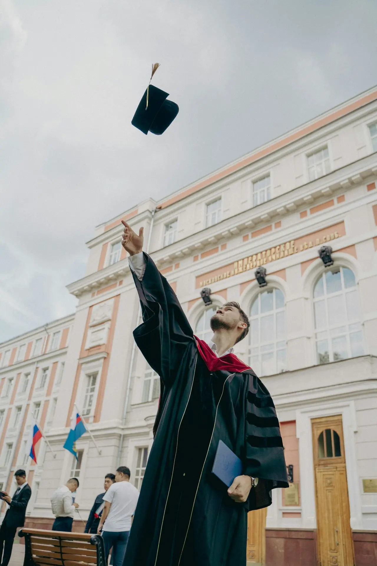 a person in a robe holding a gun in front of a building